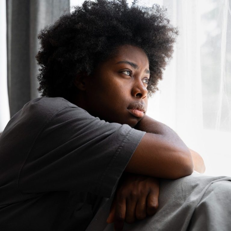 a woman looking through a window, thinking